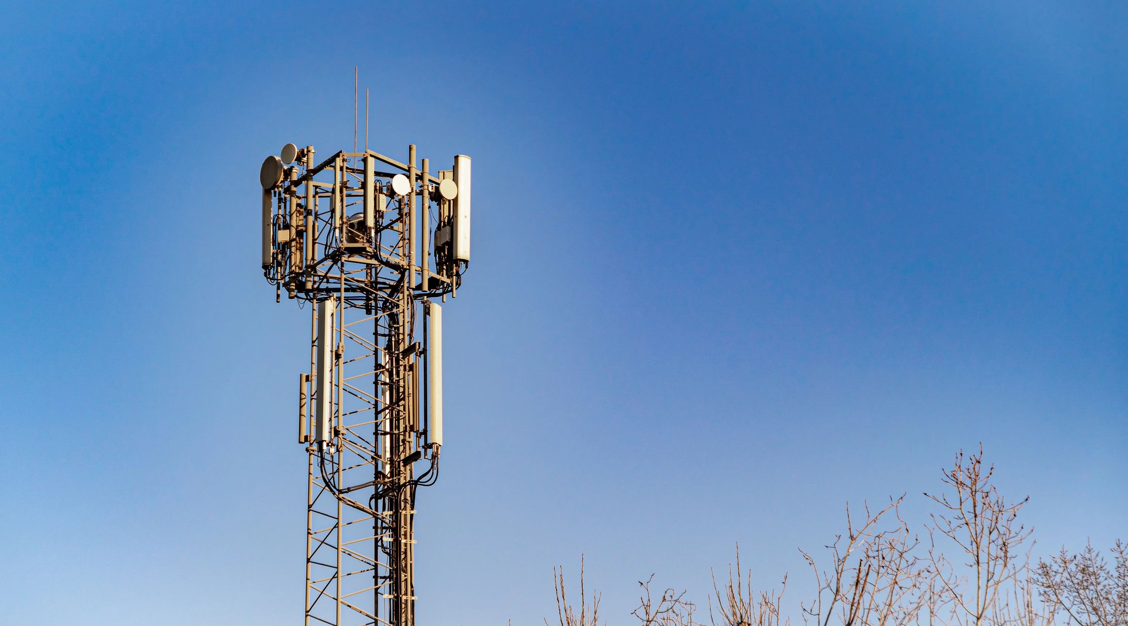 Mobile communications tower against blue sky