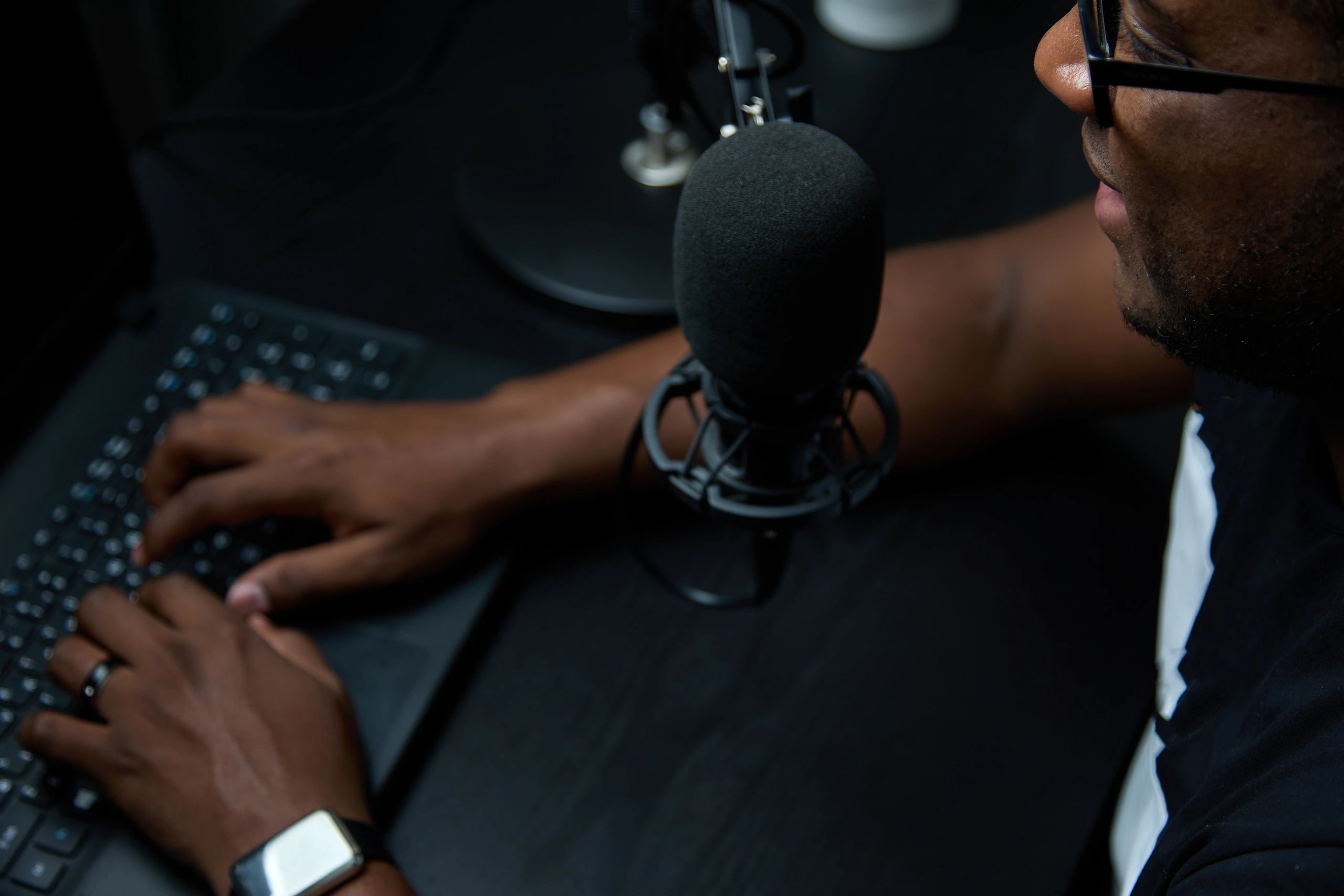 Radio host wearing headphones speaking into microphone