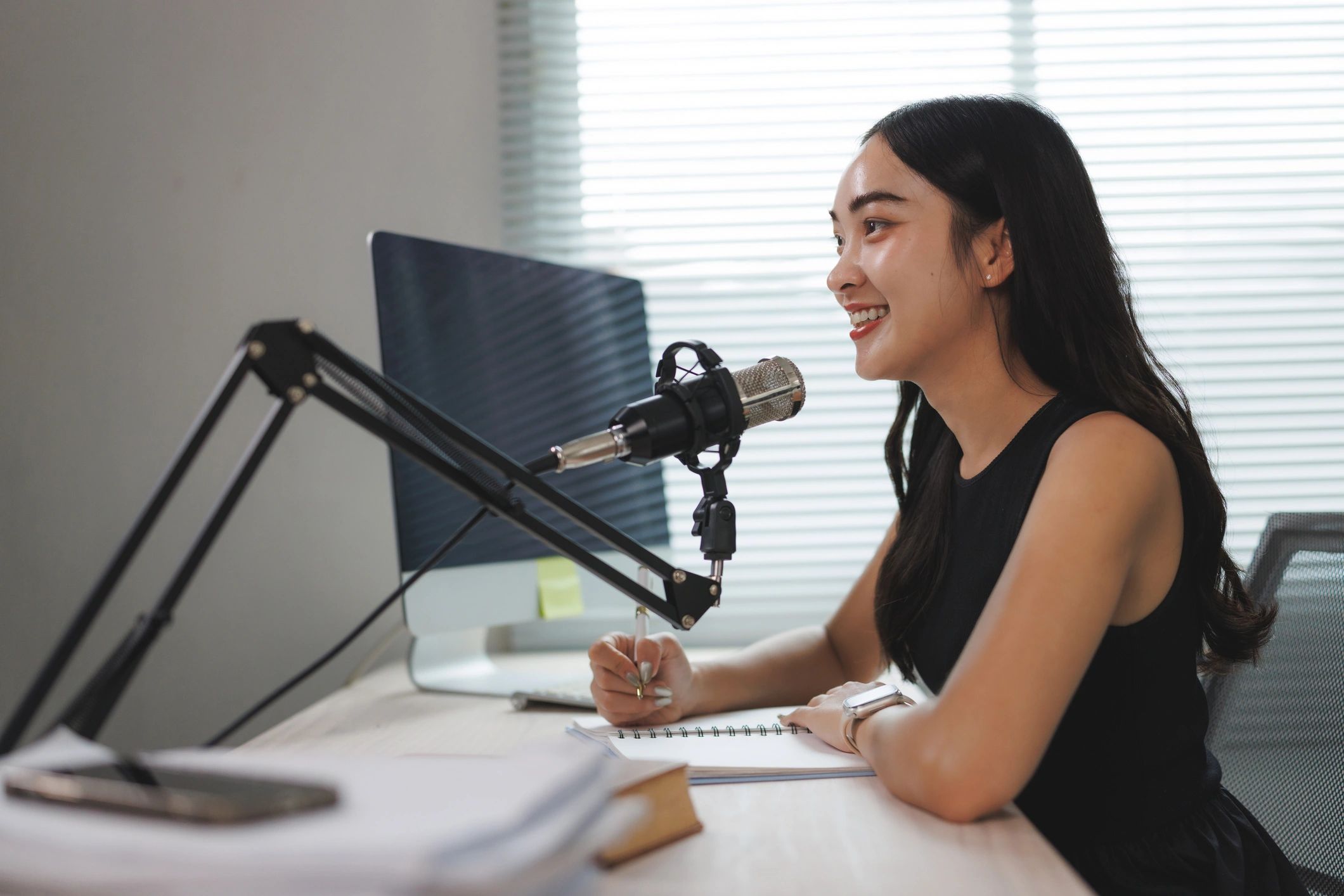 Host recording a podcast episode at a desk