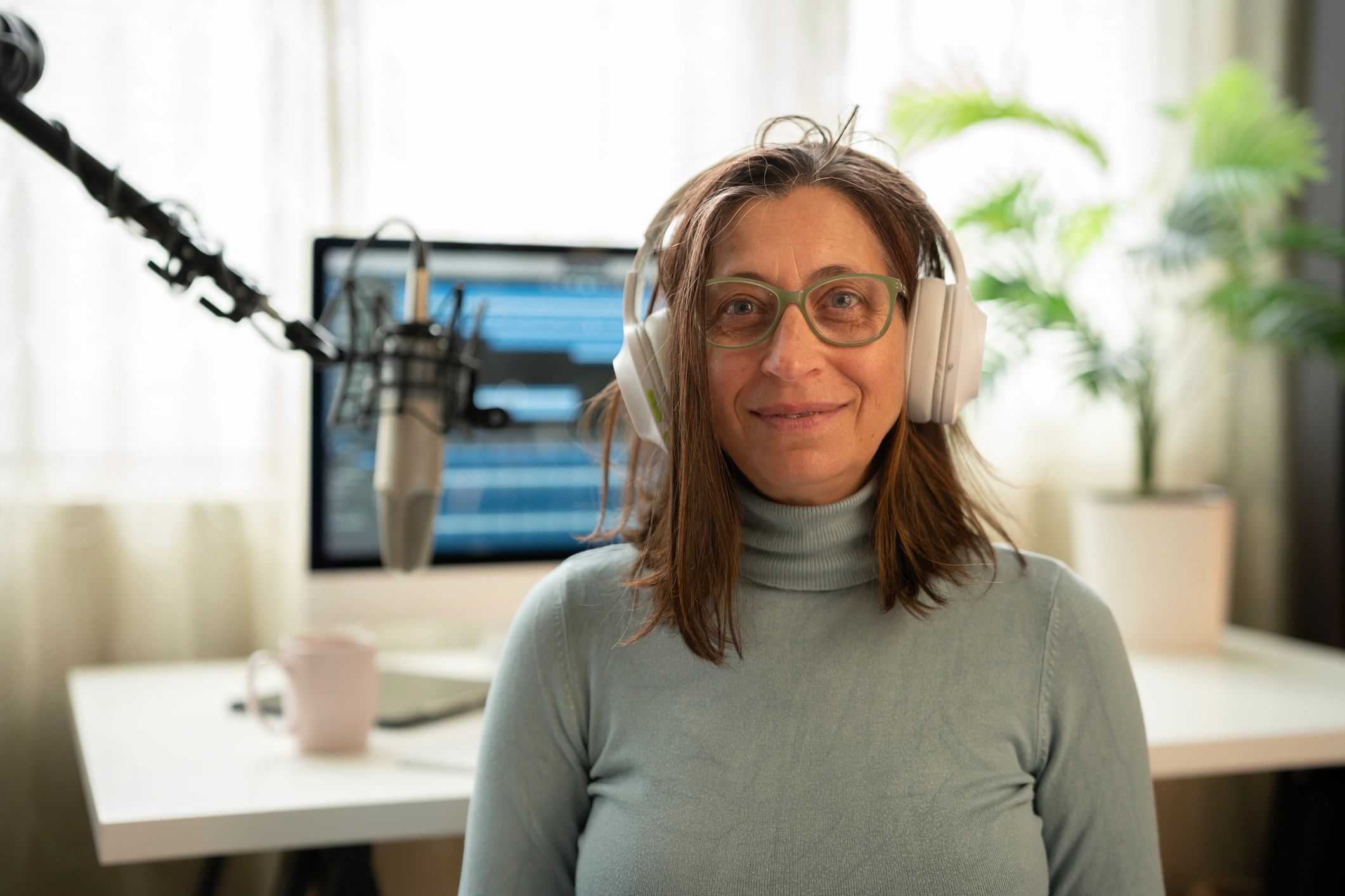 Podcast host recording with headphones in a studio