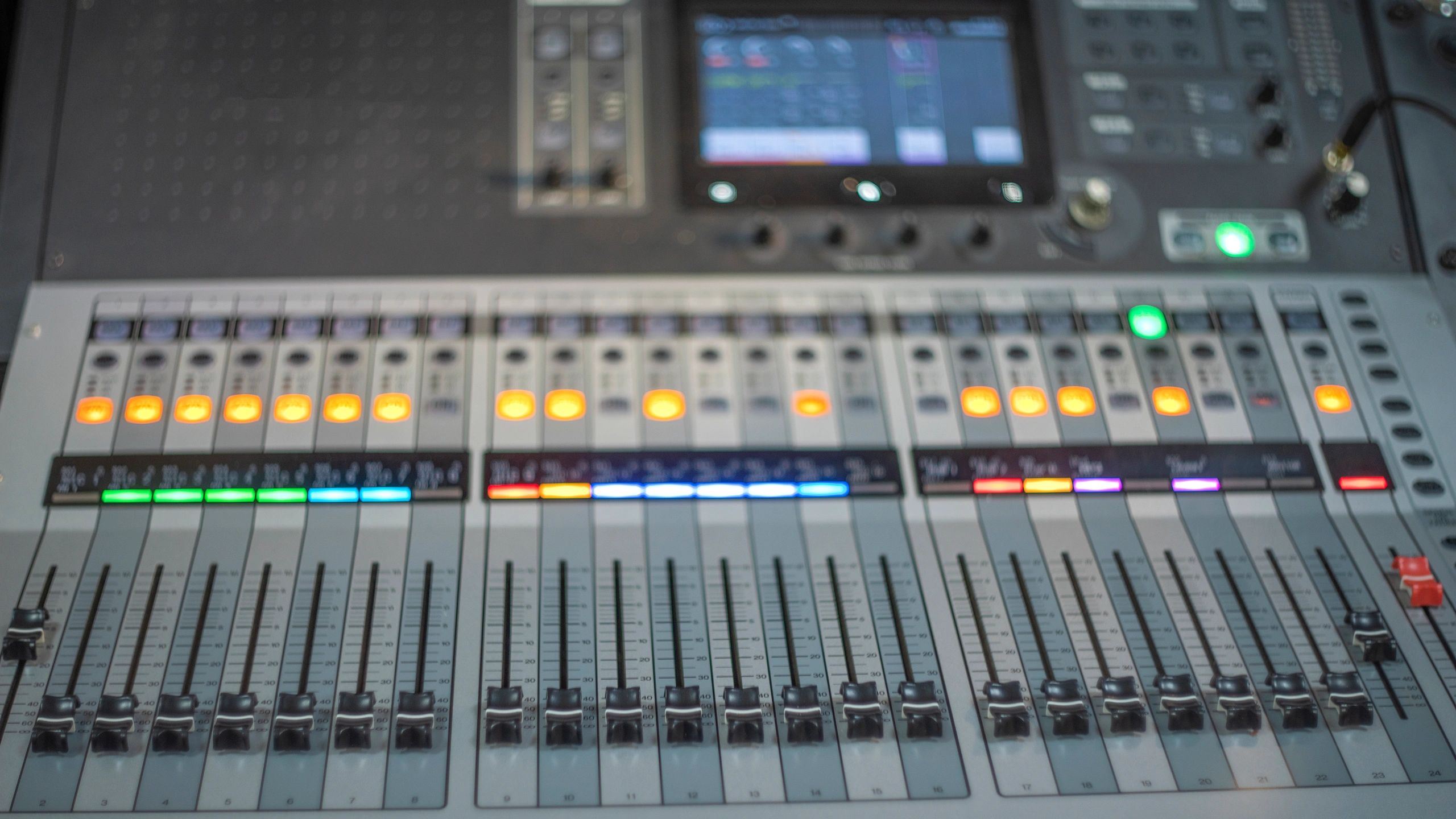 Audio mixing desk with faders and studio lights
