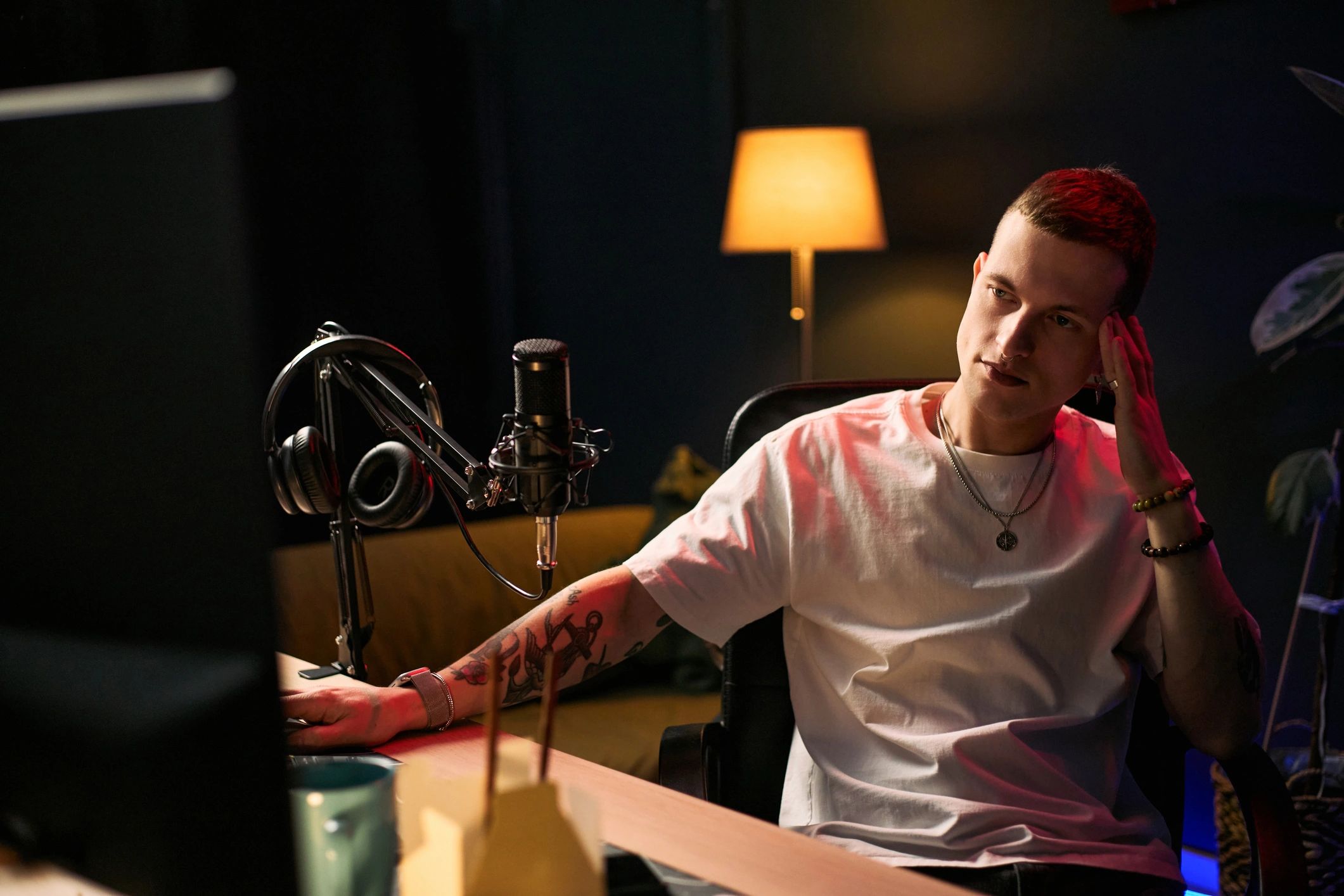 Creator streaming with microphone and headphones at a desk